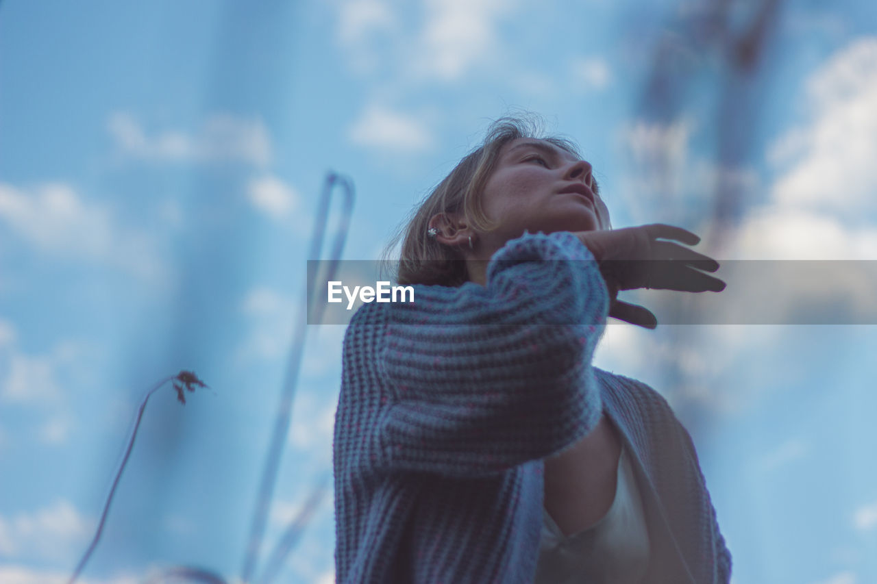 Low angle view of woman dancing against sky