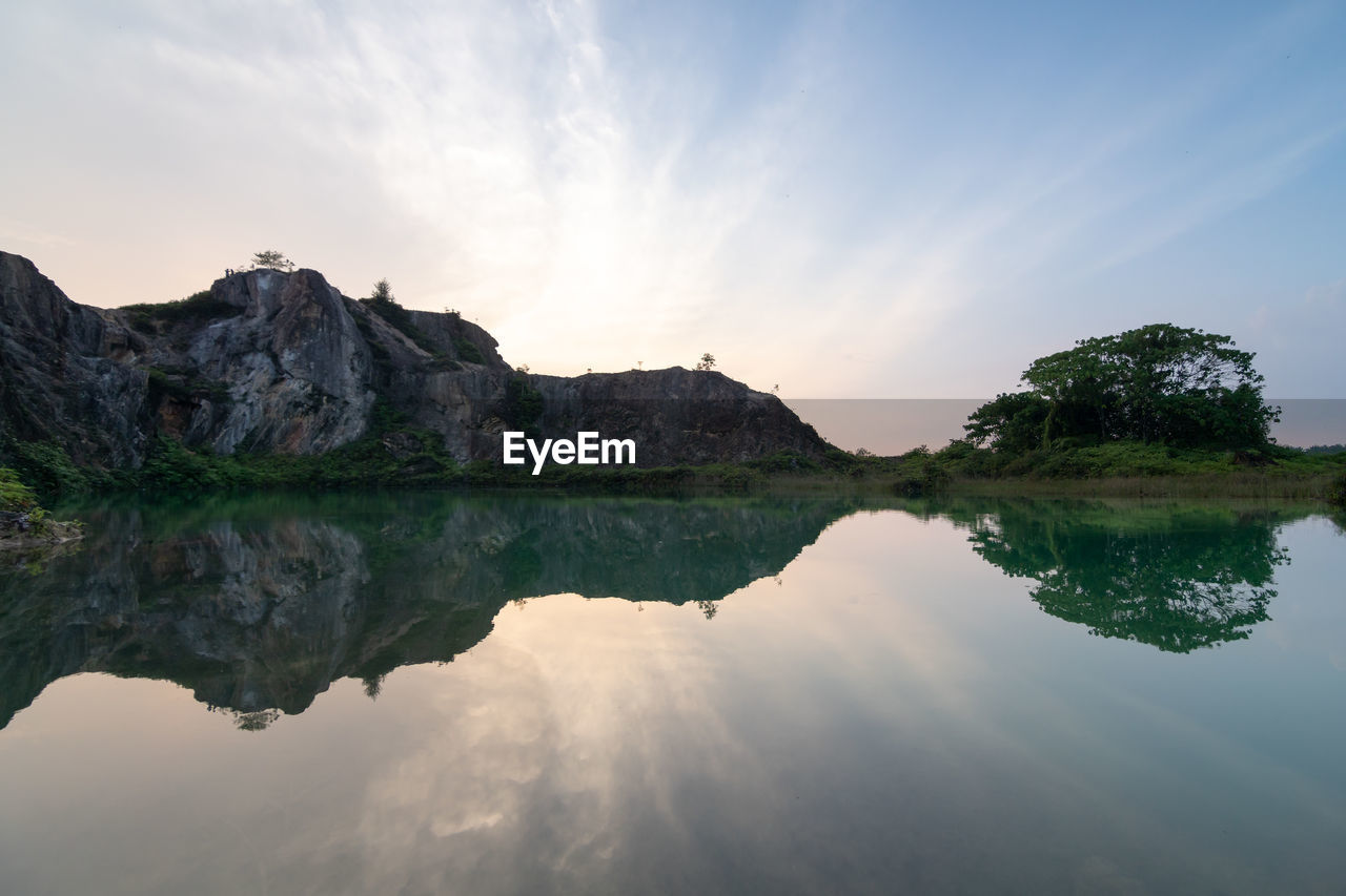 water, reflection, nature, sky, lake, scenics - nature, beauty in nature, environment, landscape, tranquility, cloud, mountain, tranquil scene, travel destinations, land, tree, body of water, no people, rock, travel, sun, outdoors, reservoir, reflection lake, non-urban scene, sunset, plant, blue, forest, idyllic, tourism, beach, standing water, lagoon, mountain range, sunlight, trip