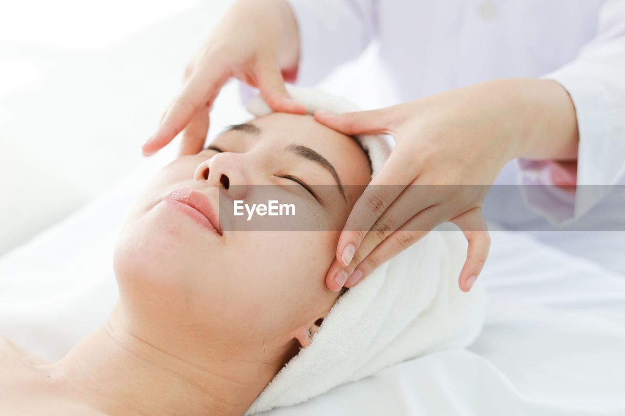 Midsection of woman massaging customer lying on table