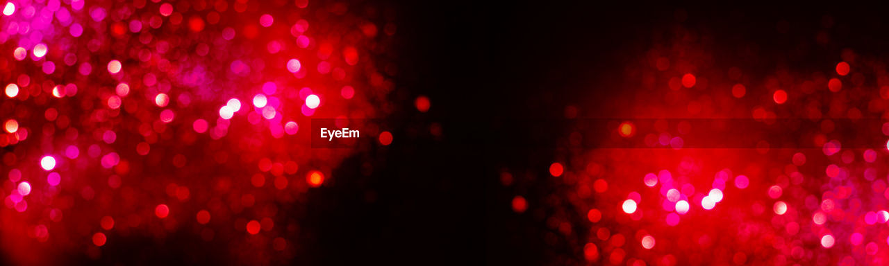 Defocused image of illuminated red lights at night