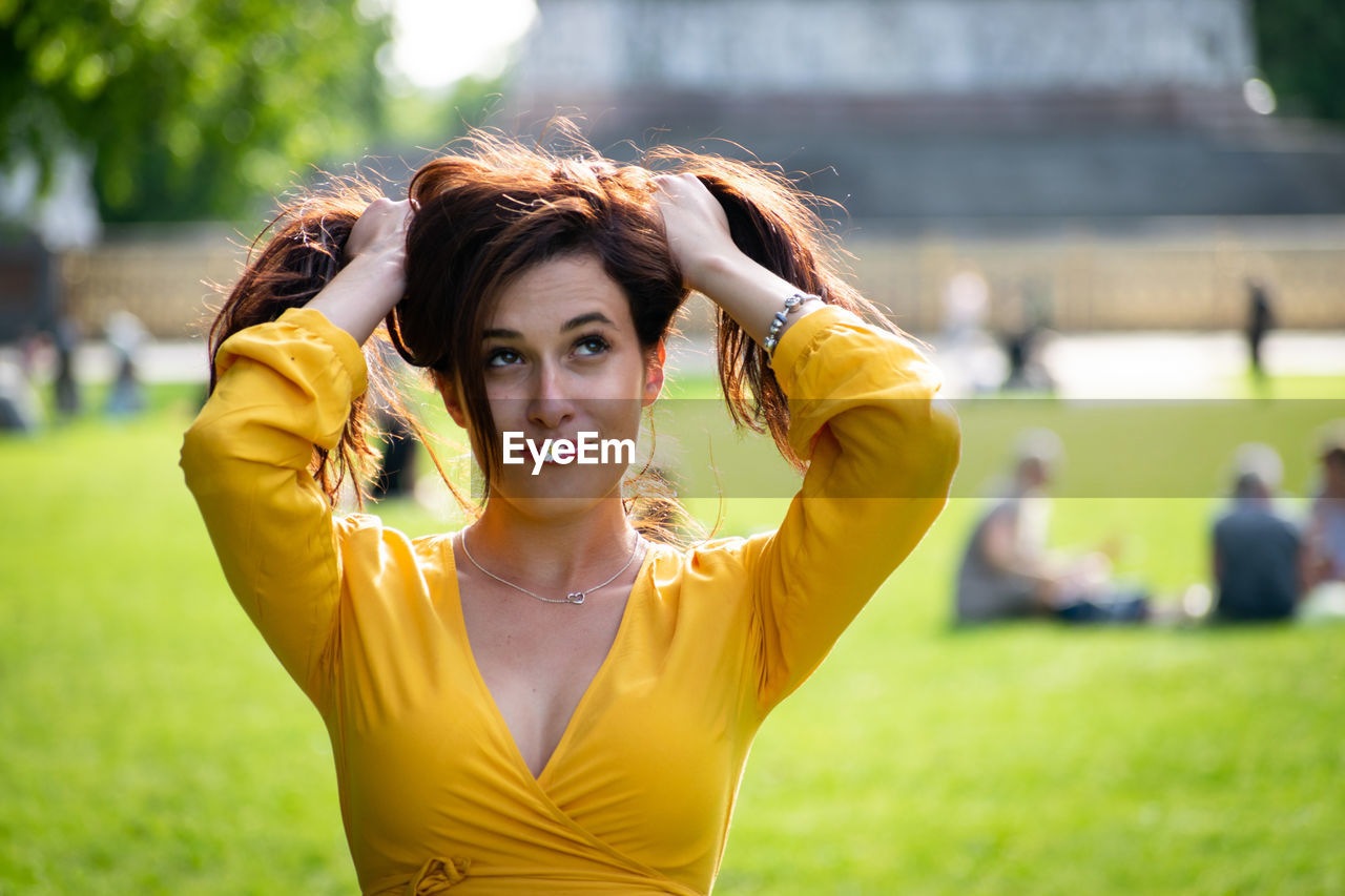 Funny woman holding hair at park