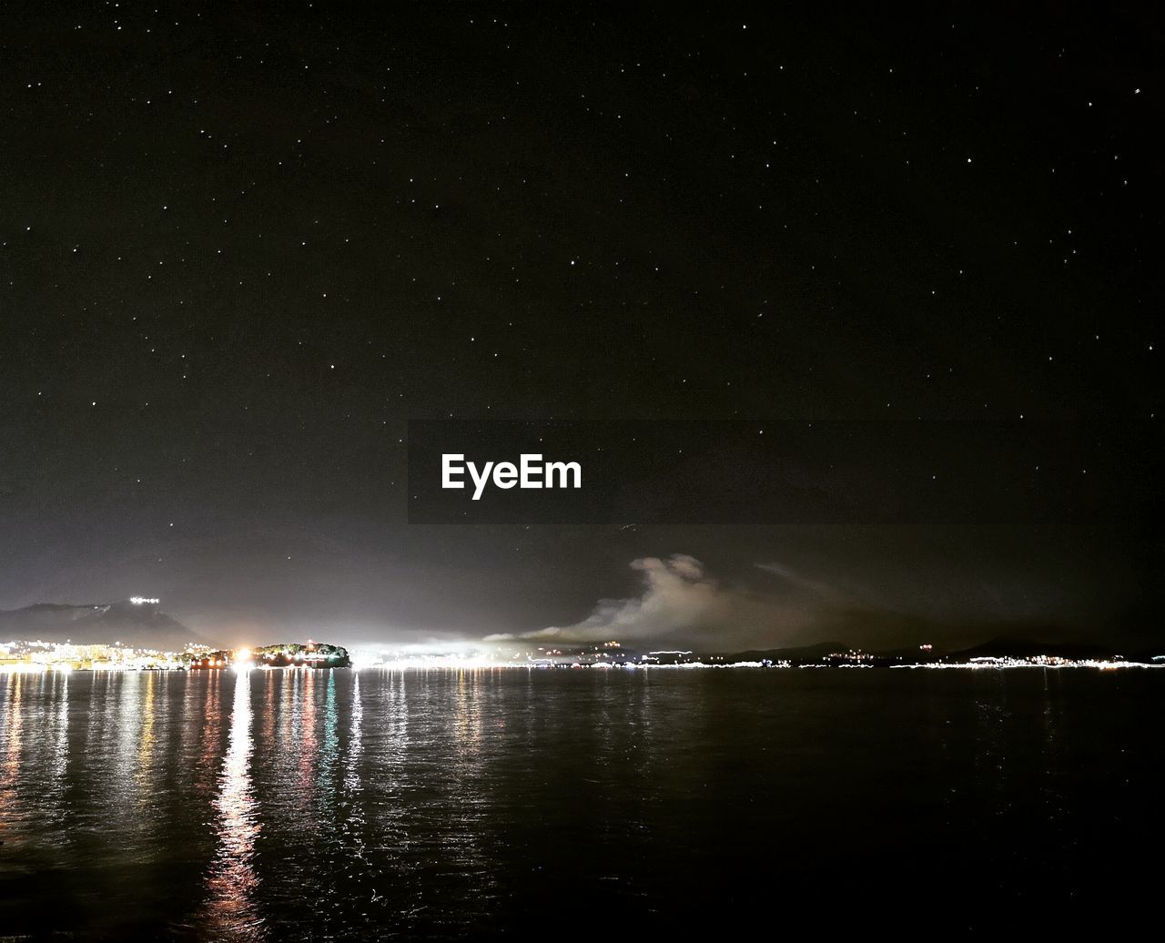 Scenic view of lake against sky at night