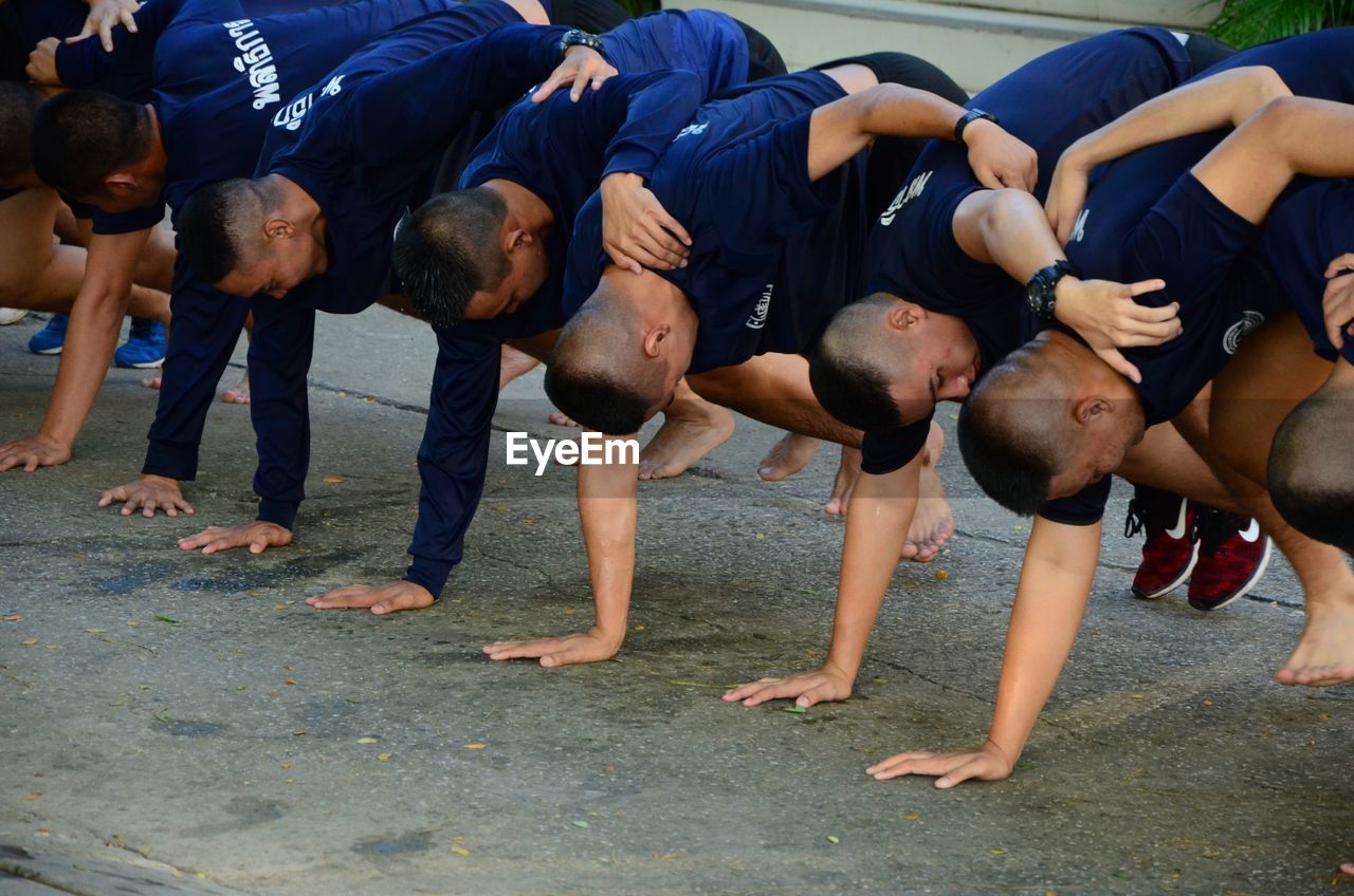 People exercising while bending on road