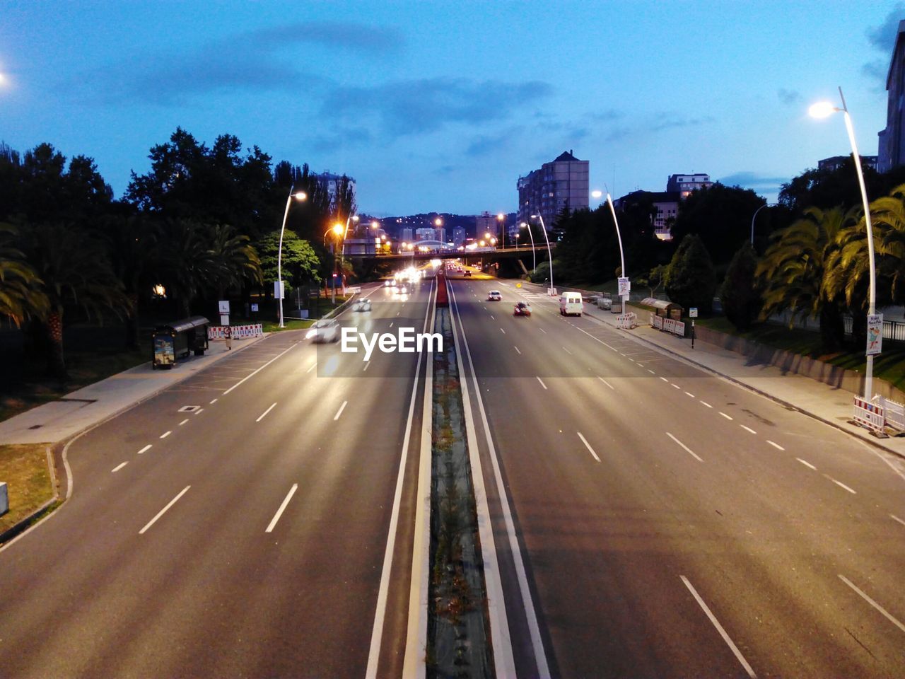 Cars on illuminated street at dusk