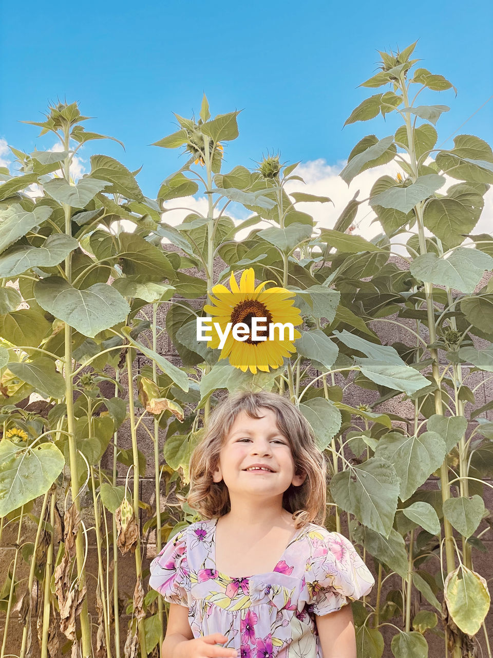 Portrait of smiling girl against blue sky