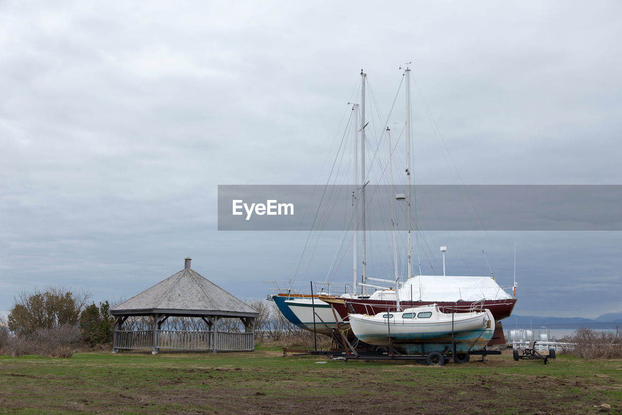 Sailboats moored on sea against sky