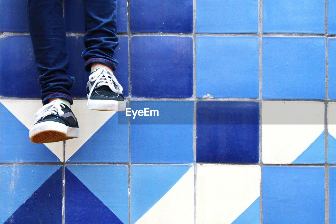 LOW SECTION OF WOMAN IN TILED FLOOR