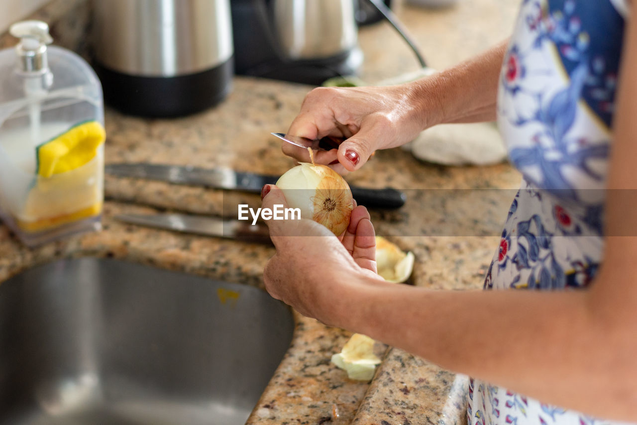 Cook peeling onion in the kitchen. healthy eating.