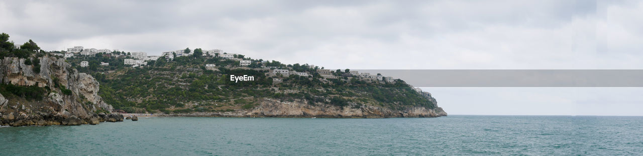 PANORAMIC VIEW OF SEA AND ROCKS AGAINST SKY