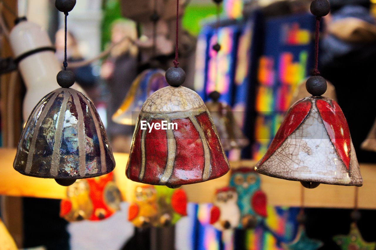 Close-up of multi colored bells hanging for sale in market