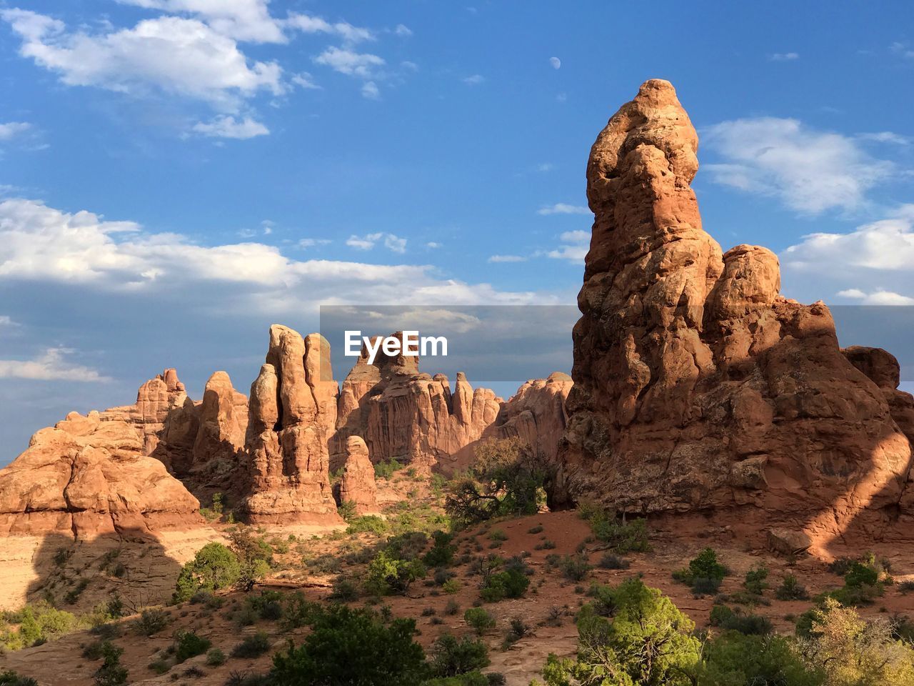 Rock formations on landscape against cloudy sky