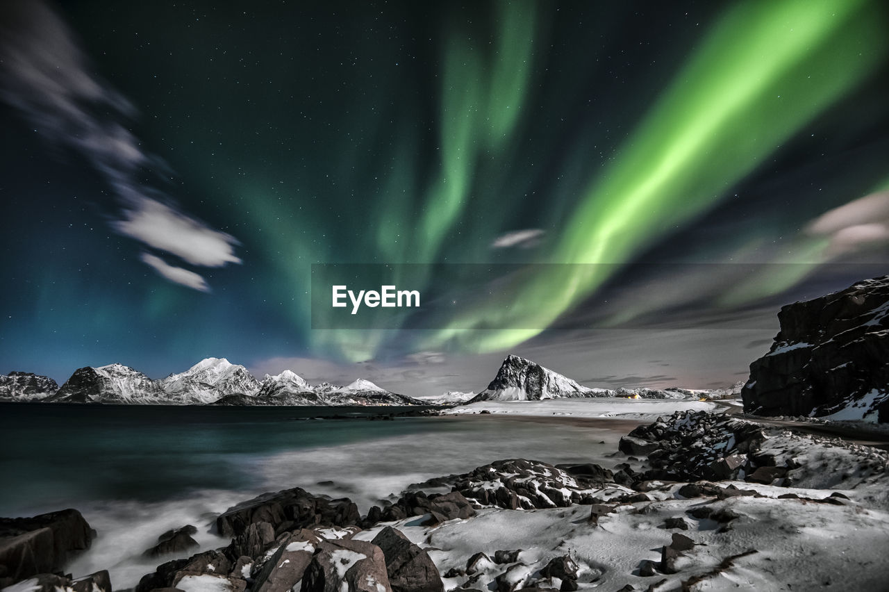 Scenic view of snowcapped mountains against sky at night during winter