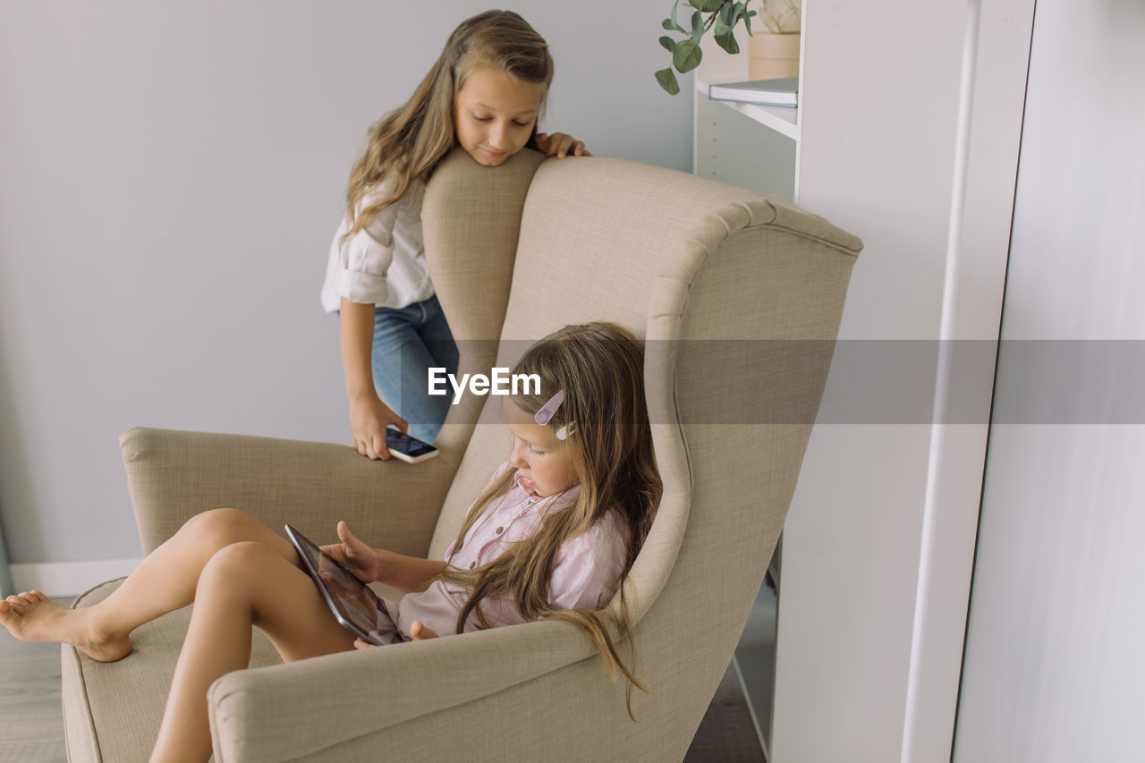 Siblings using digital tablet at home