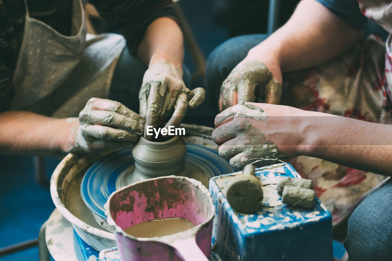 Midsection of potters making pottery