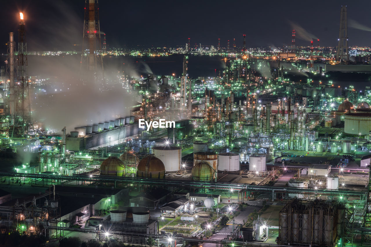 Aerial view of illuminated industry against sky at night