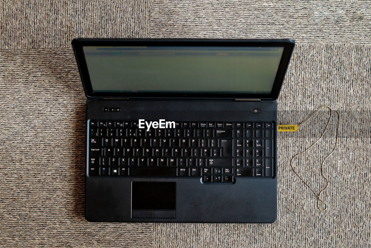 Directly above shot of laptop connected to usb stick on carpet