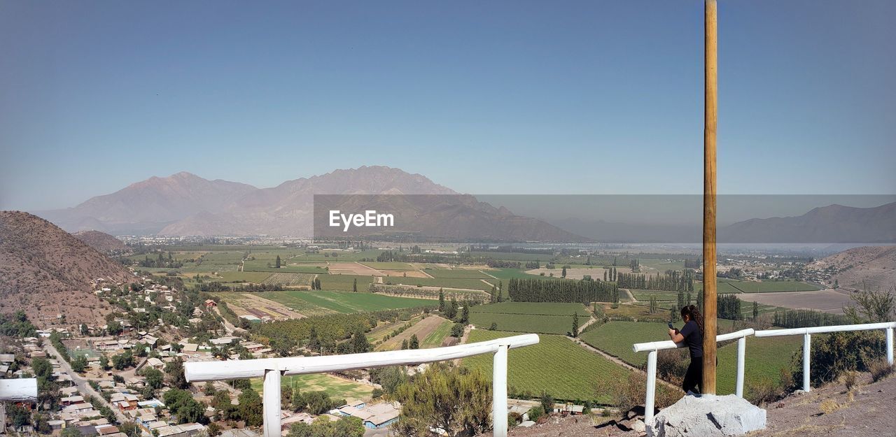 Scenic view of field and mountains against clear sky