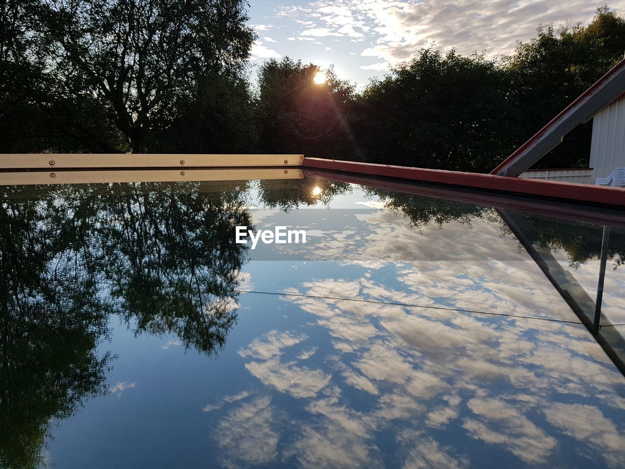 REFLECTION OF TREE IN LAKE AGAINST SKY