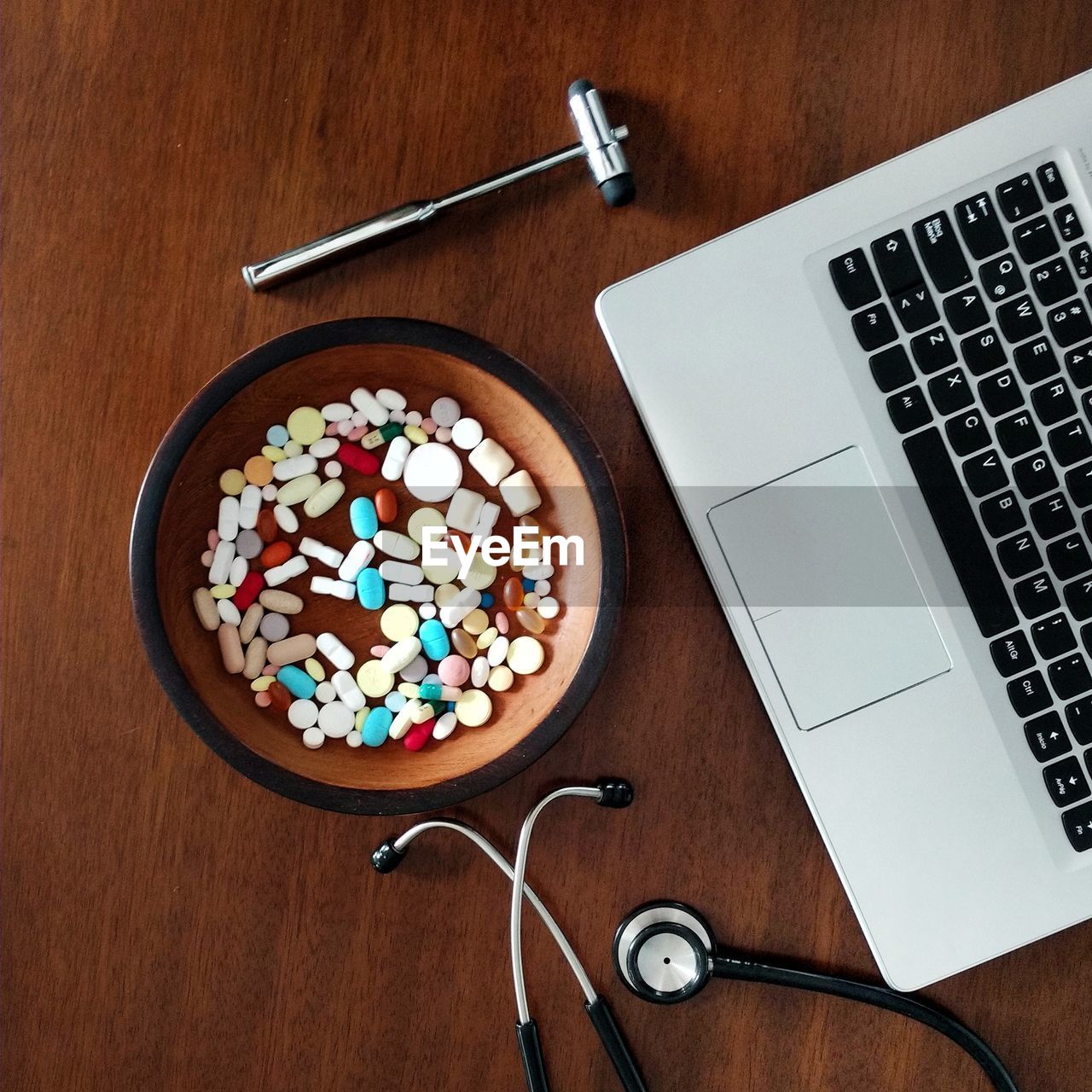 High angle view of laptop and pills on table