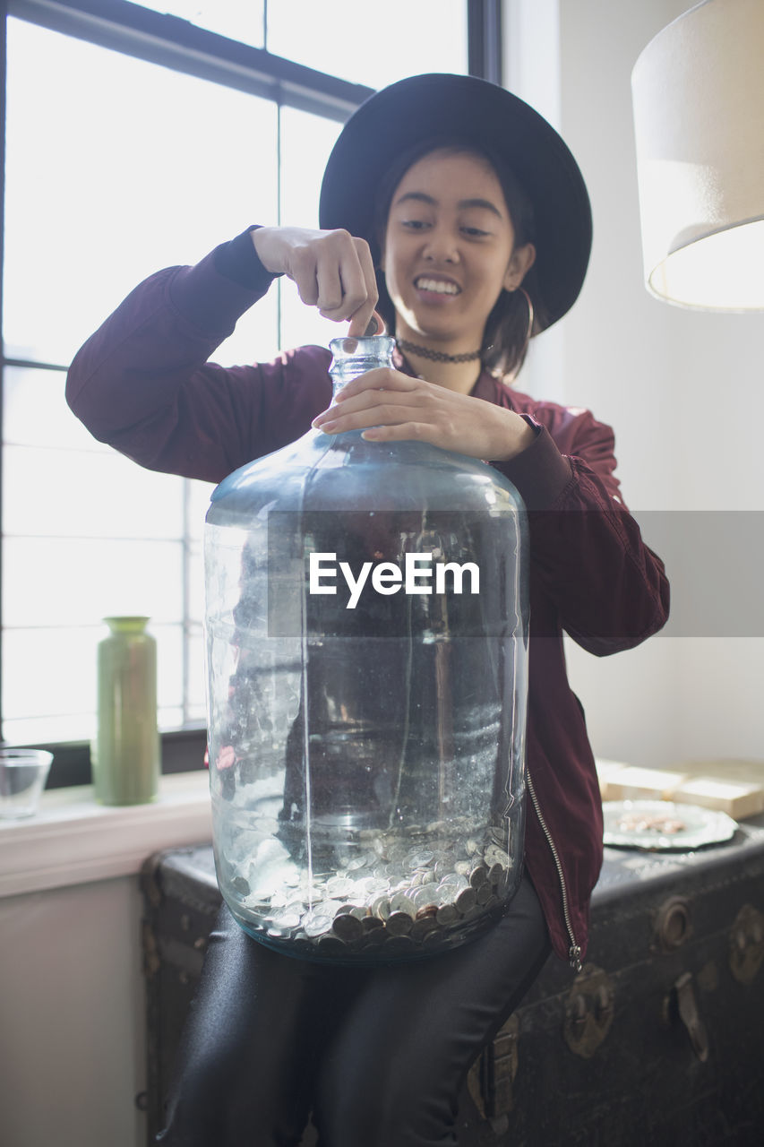 A young woman holding an empty water tank