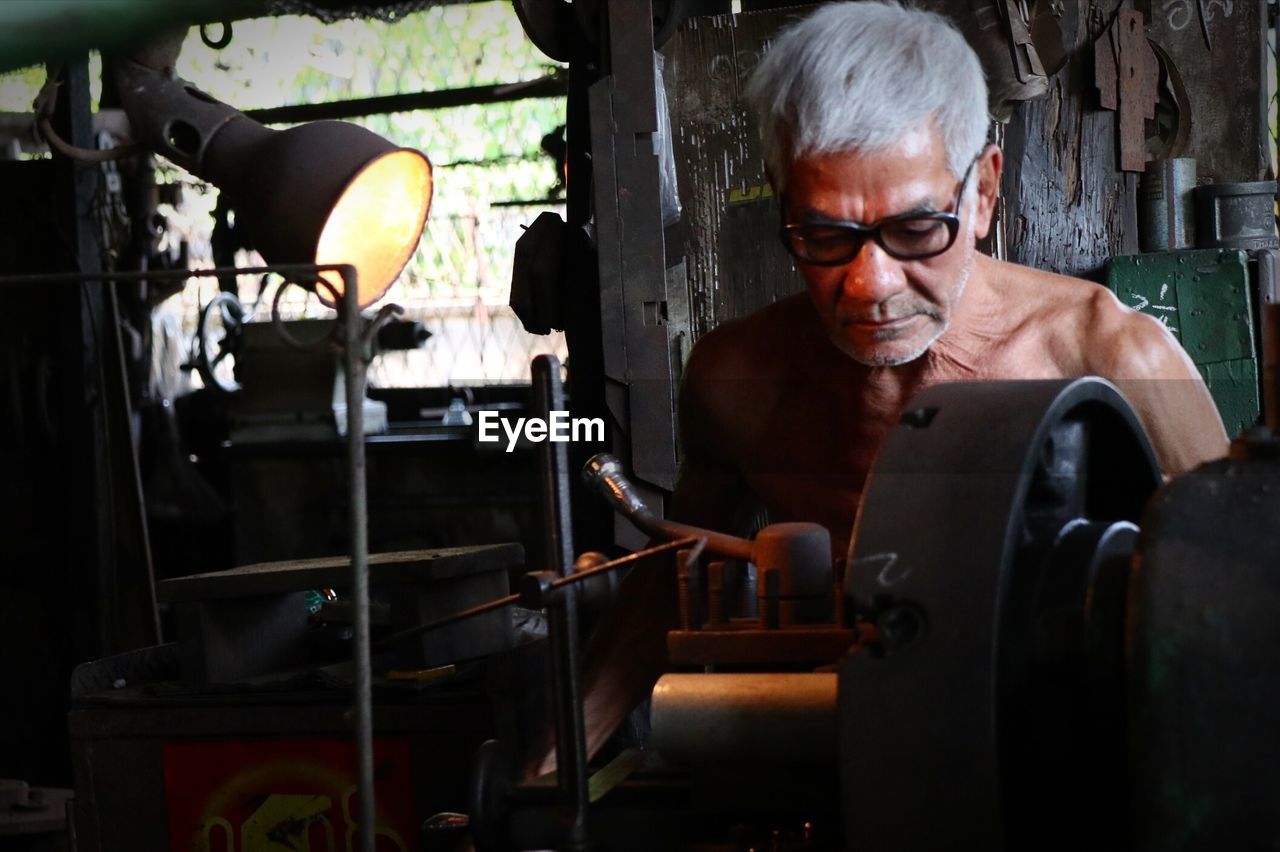 Close-up of senior man working in factory