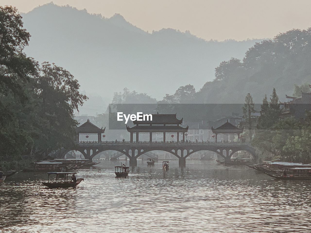 Scenic view of river by houses against sky