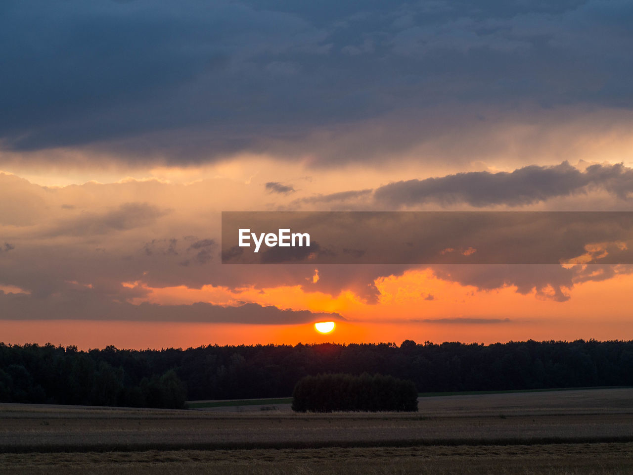 SCENIC VIEW OF FIELD AGAINST ORANGE SKY DURING SUNSET