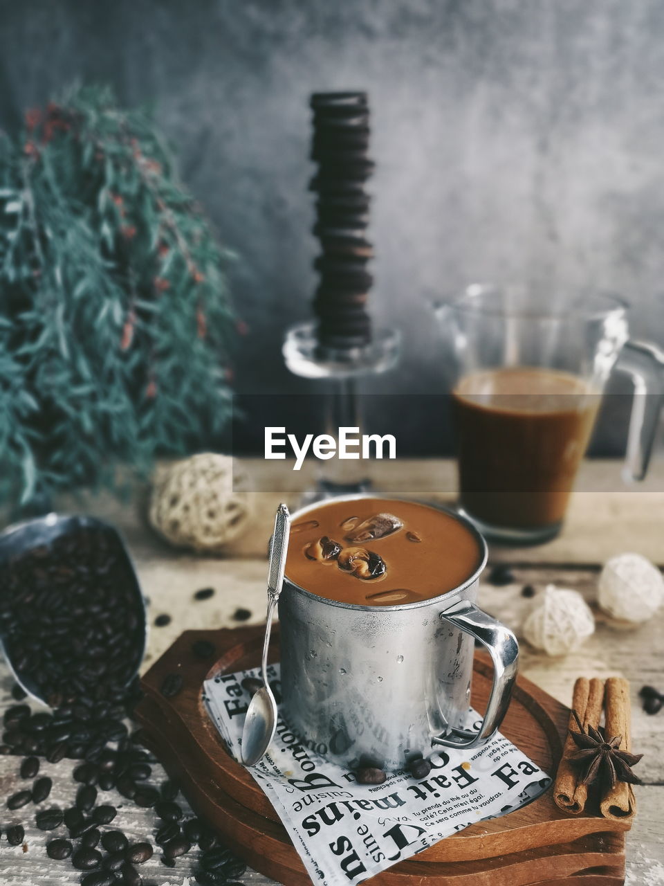 CLOSE-UP OF COFFEE CUP ON GLASS TABLE WITH SPOON