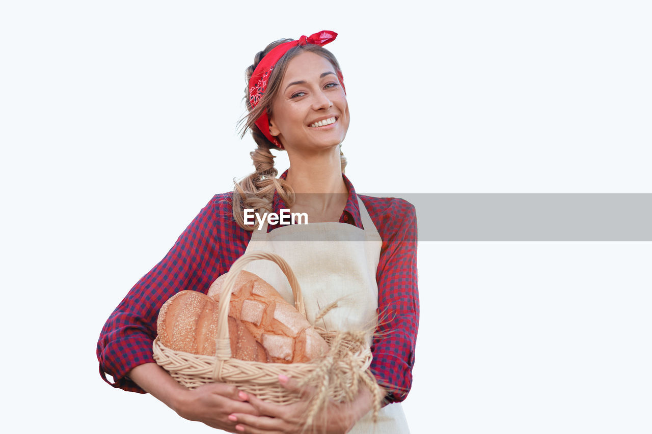 PORTRAIT OF A SMILING YOUNG WOMAN HOLDING ICE CREAM