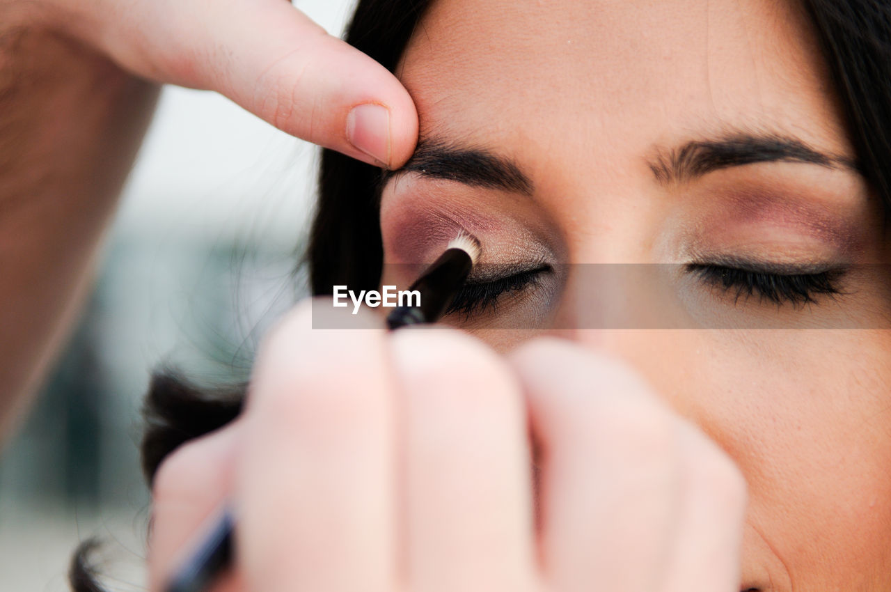 Woman applying eyeshadow on friend eye