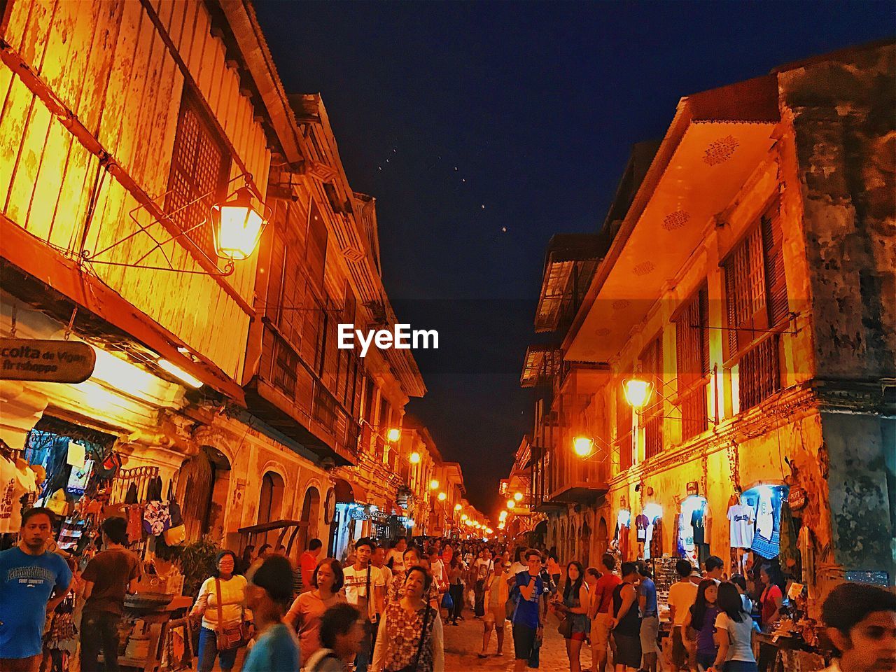 CROWD AT ILLUMINATED MARKET AGAINST SKY AT NIGHT