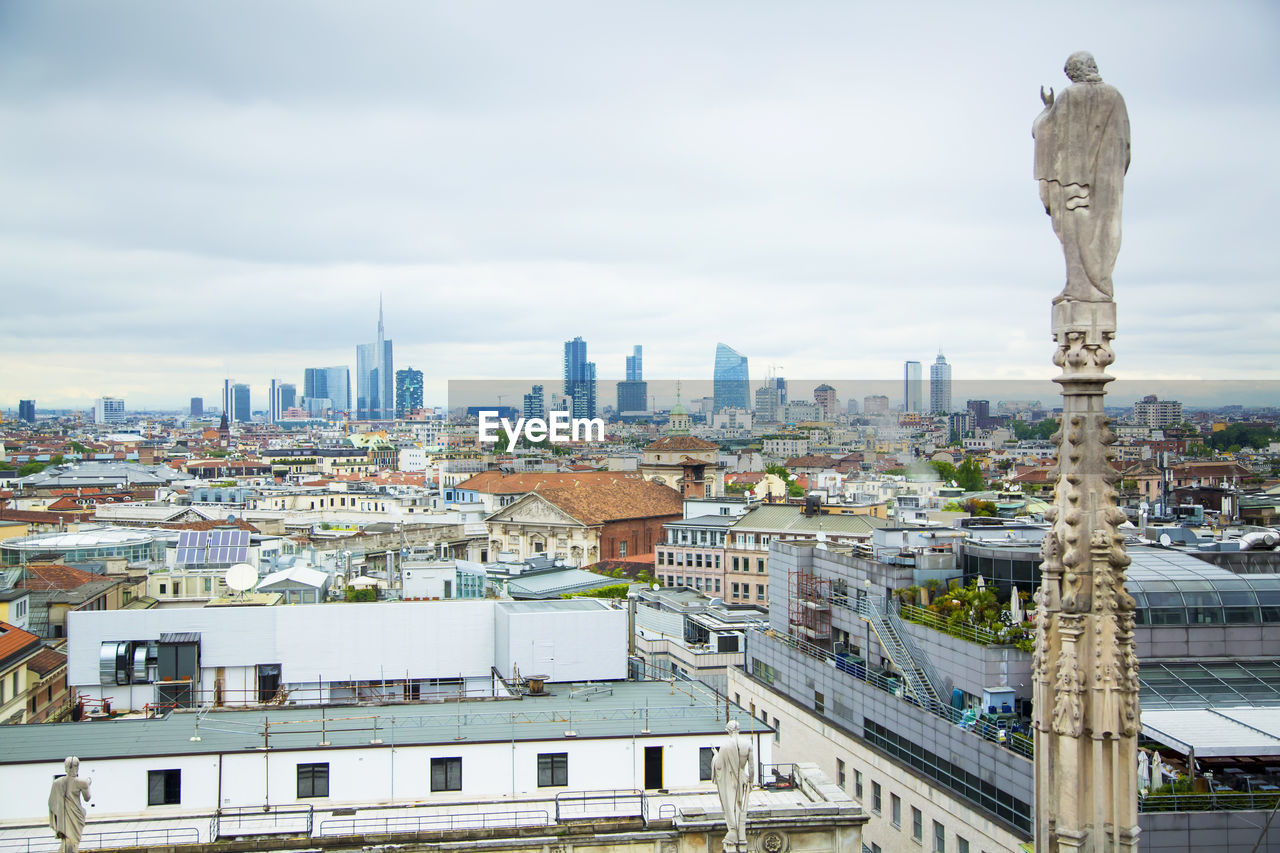 View of cityscape against cloudy sky