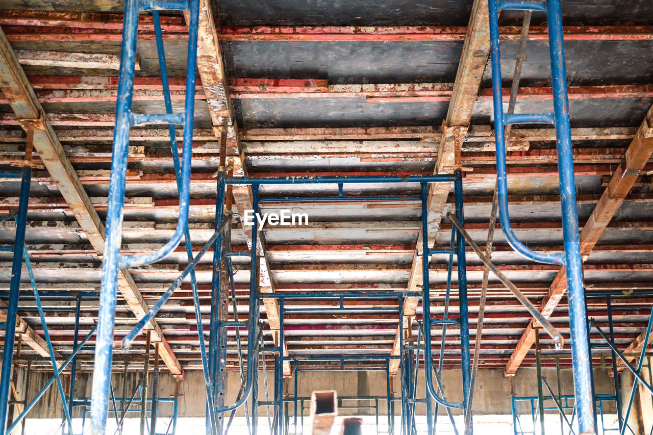 Setting up steel scaffolding to support floors for concrete work on tall buildings. a view up under.