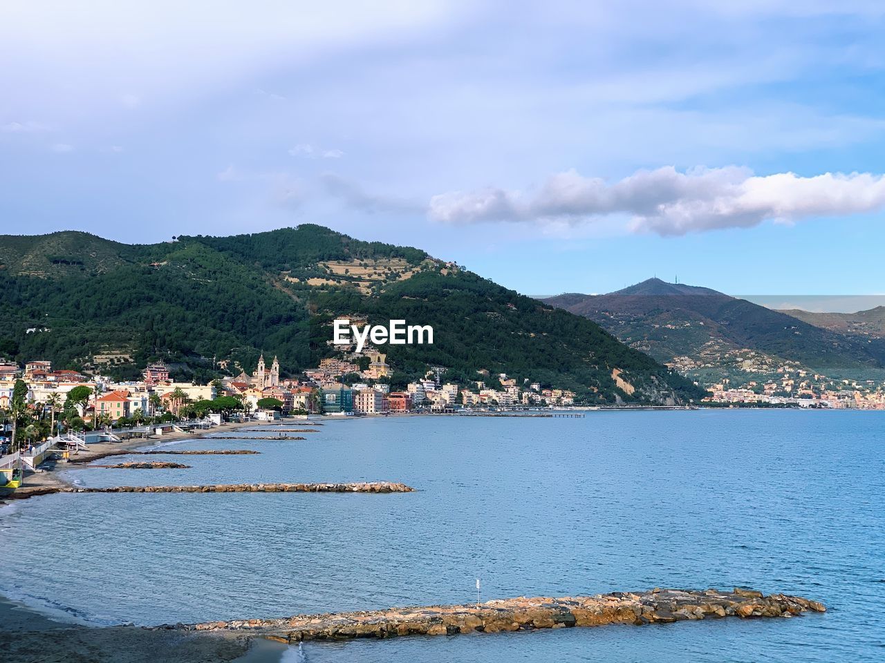 Scenic view of sea by buildings against sky