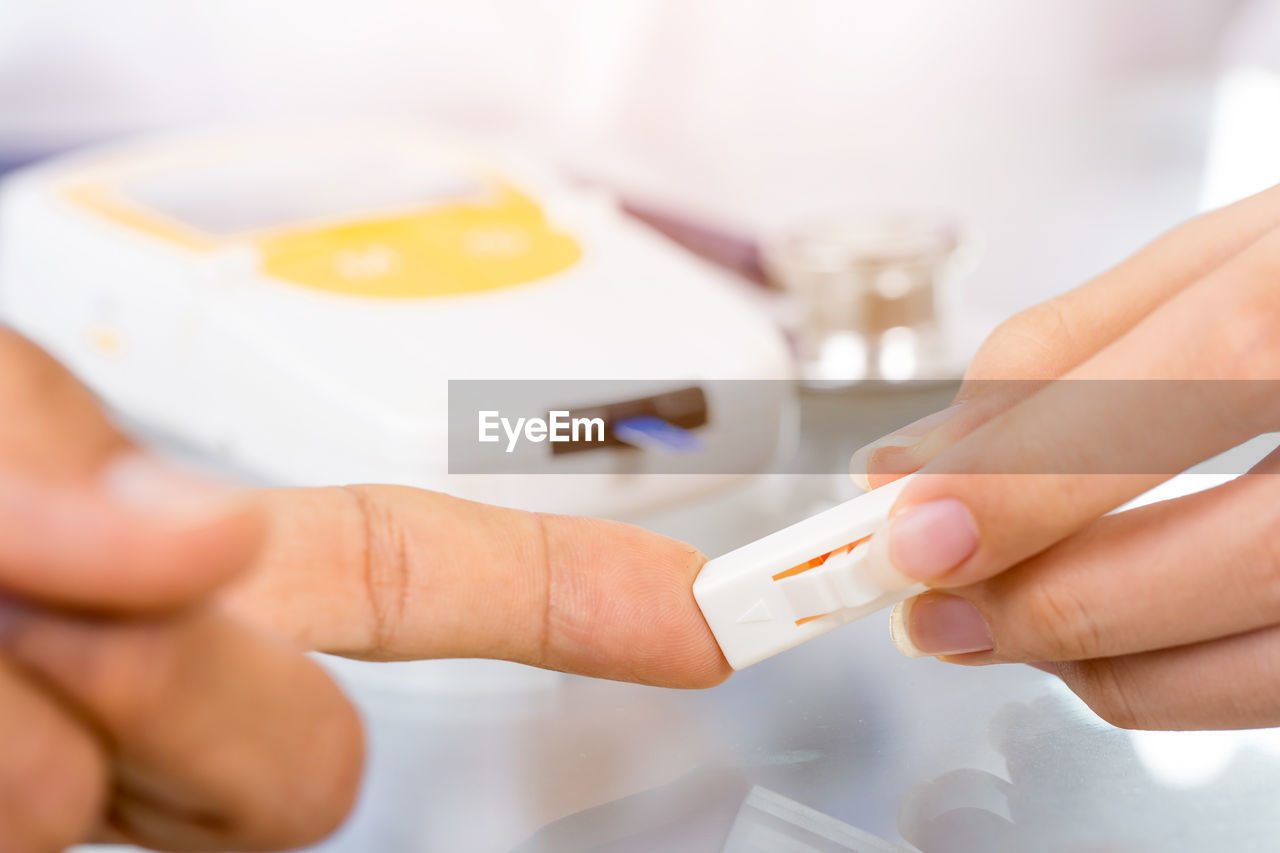 Cropped hand of doctor checking patient diabetes in hospital 