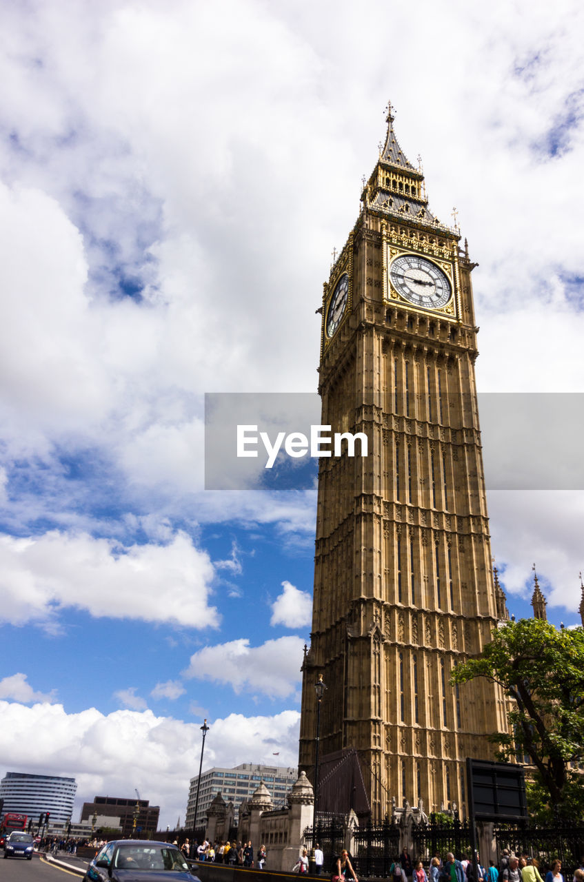 Low angle view of clock tower against cloudy sky