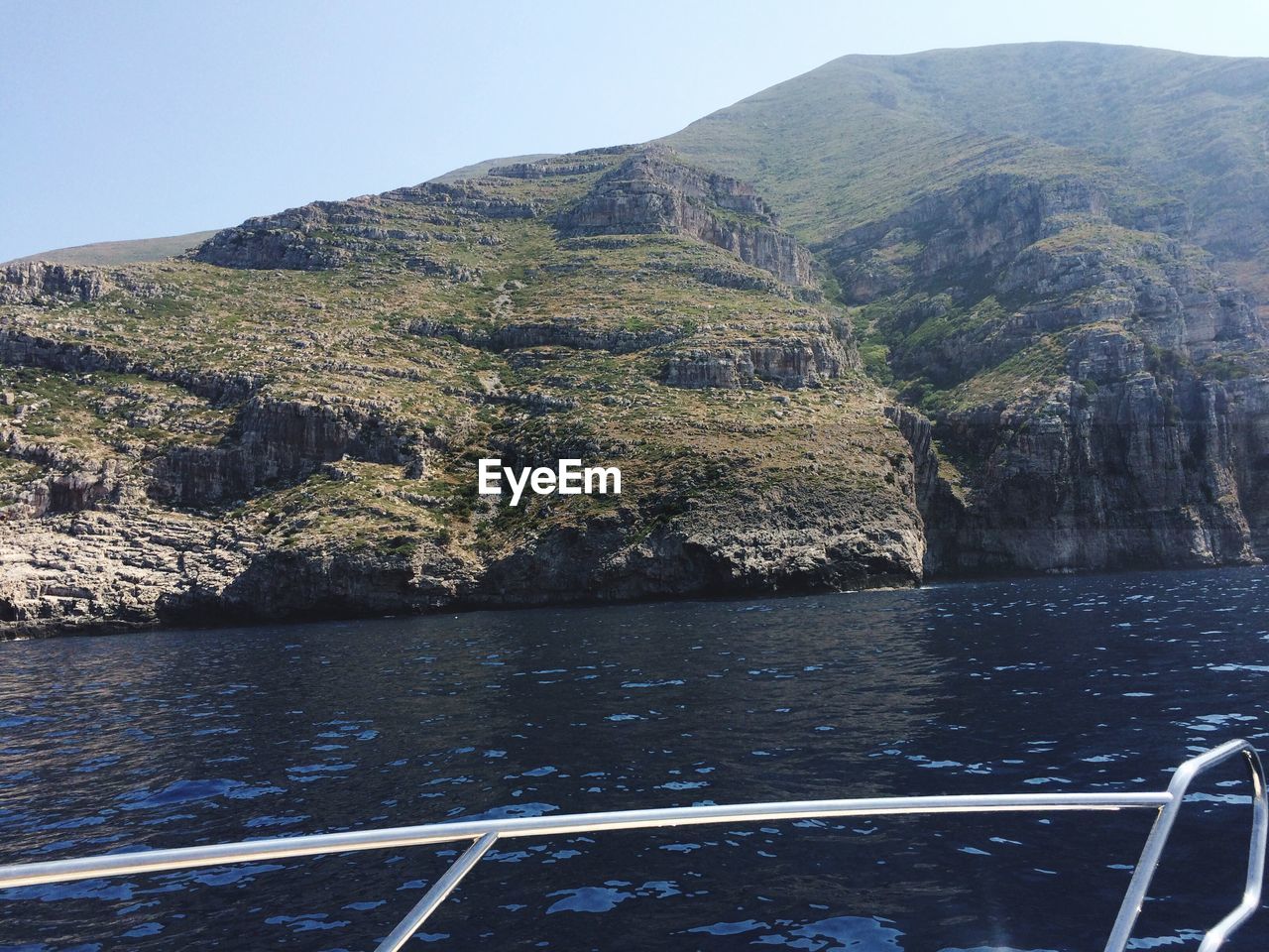 Aerial view of sea and mountains against clear sky