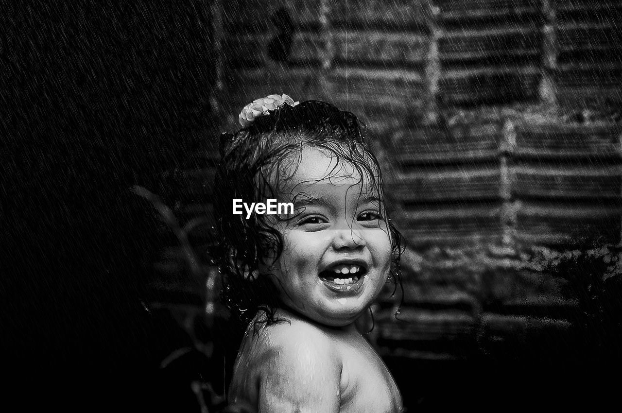 Close-up portrait of shirtless girl at fountain