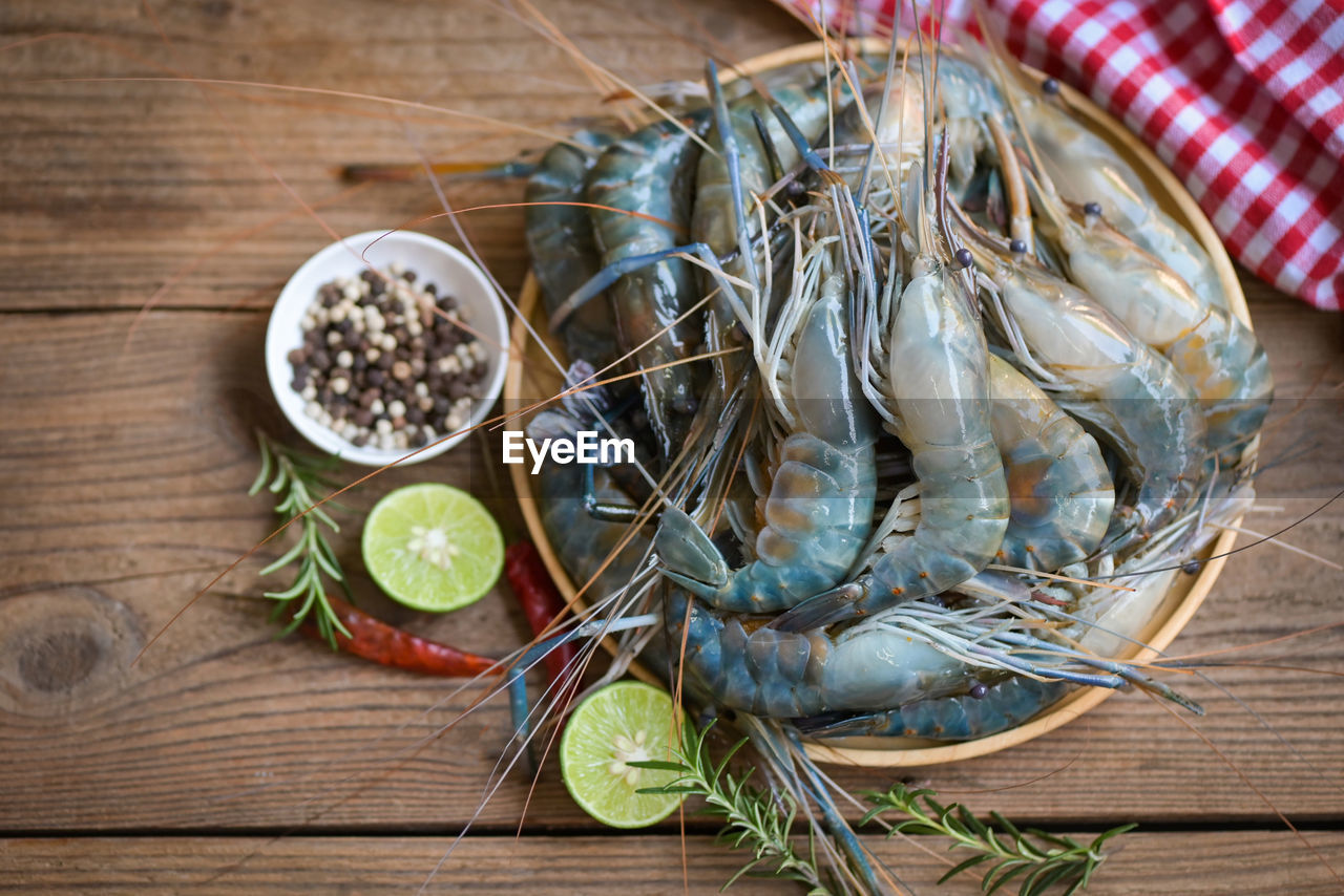food and drink, food, healthy eating, freshness, wood, wellbeing, seafood, fruit, table, animal, no people, indoors, rustic, ingredient, high angle view, raw food, herb, fish, citrus fruit, plant, vegetable, lemon, spice, directly above