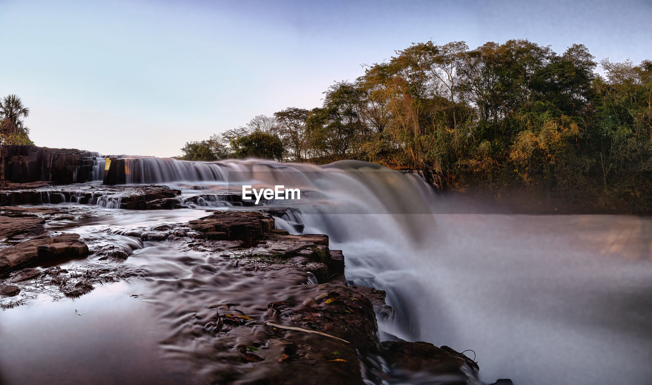 SCENIC VIEW OF WATERFALL AGAINST ROCKS