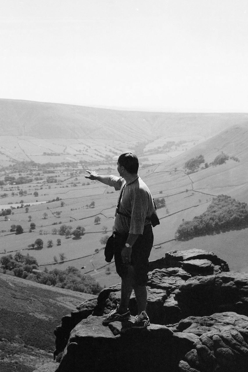 Full length of tourist watching mountains against clear sky