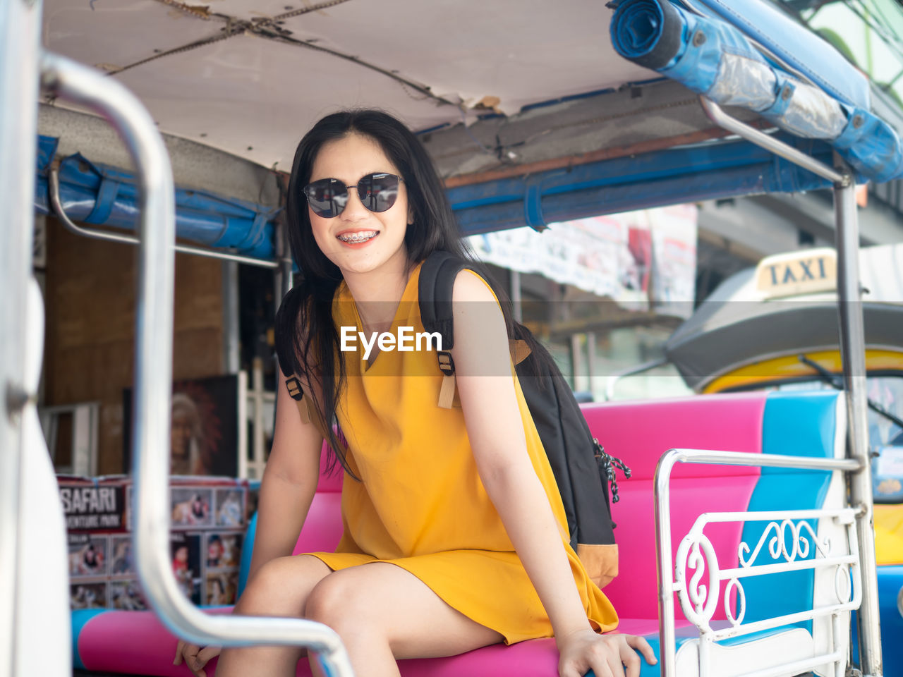Portrait of smiling young woman sitting in tuk tuk