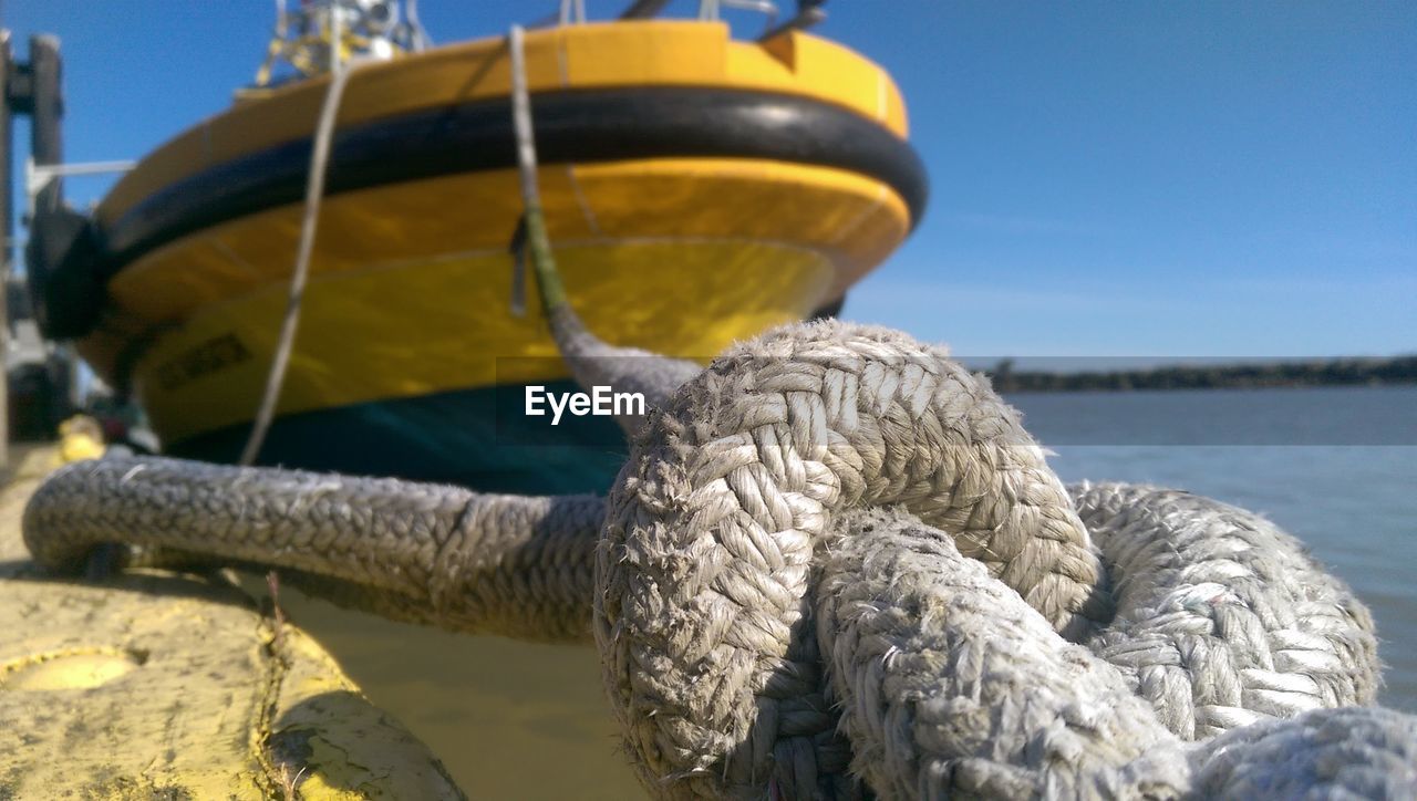 CLOSE-UP OF ROPE TIED ON PIER