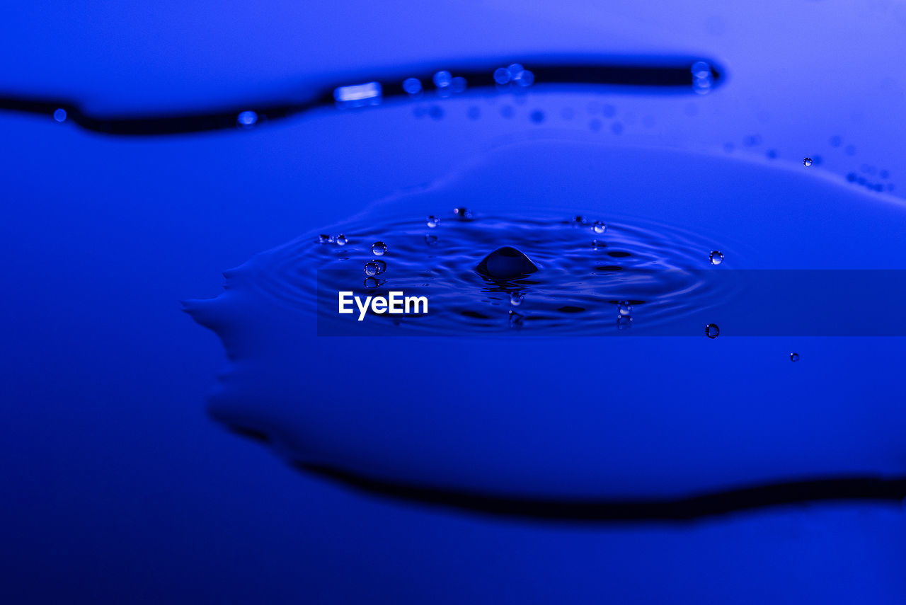 CLOSE-UP OF WATER DROP AGAINST BLUE BACKGROUND