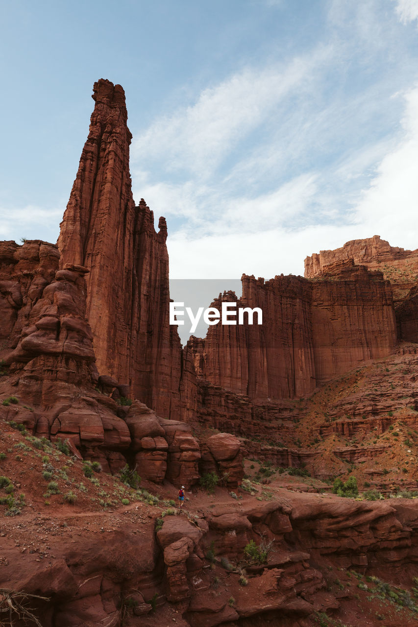 Hiker heads down path under the fisher towers near moab utah