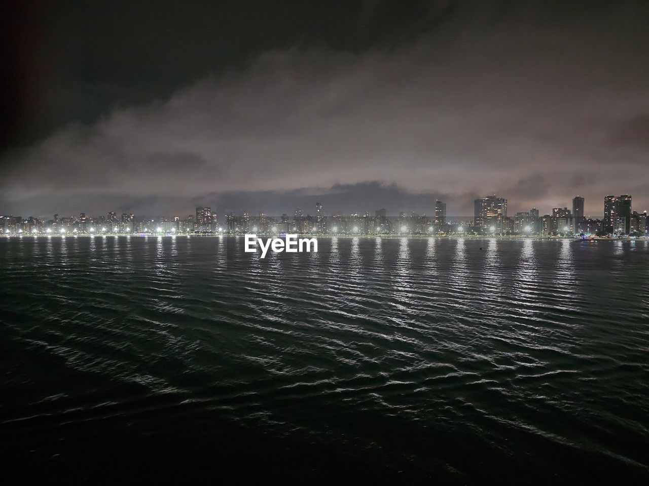 water, night, sky, architecture, building exterior, city, reflection, built structure, nature, cloud, illuminated, sea, darkness, light, no people, horizon, beauty in nature, cityscape, dusk, building, outdoors, environment, landscape, travel destinations, scenics - nature, wave, land, waterfront, motion, storm, evening, skyscraper