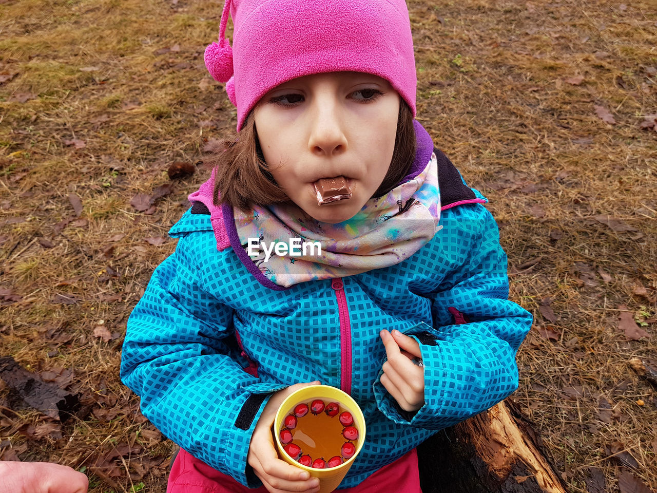 Trekking kid drinking hawthorn tea and eating chocolate in the outdoors