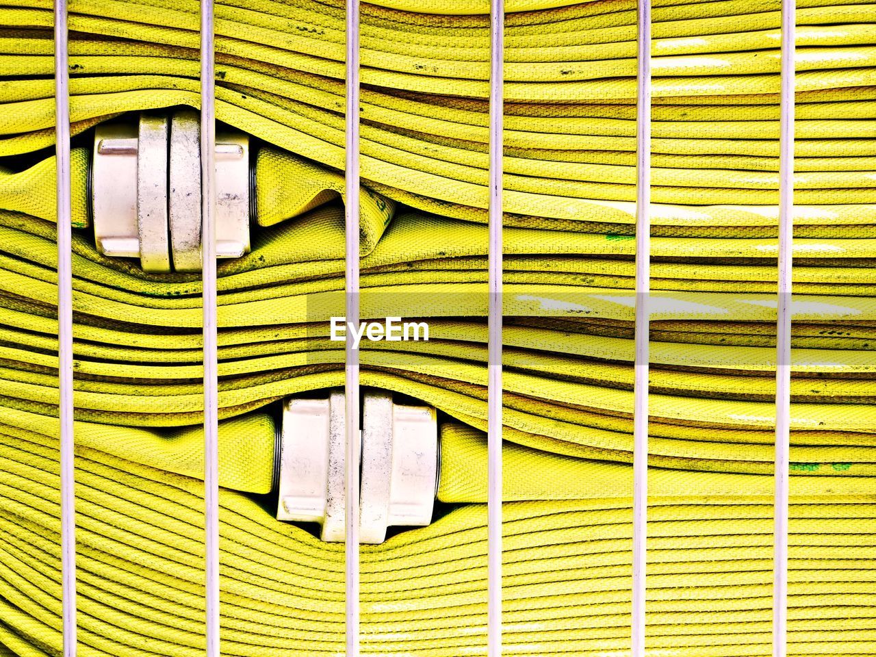 FULL FRAME SHOT OF YELLOW METAL HANGING ON WALL