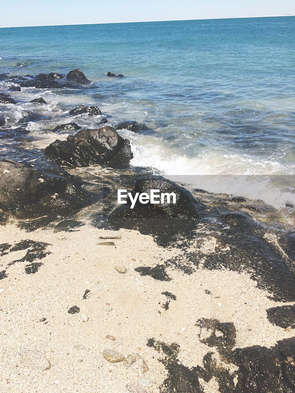 SCENIC VIEW OF SEA WITH ROCKS IN BACKGROUND