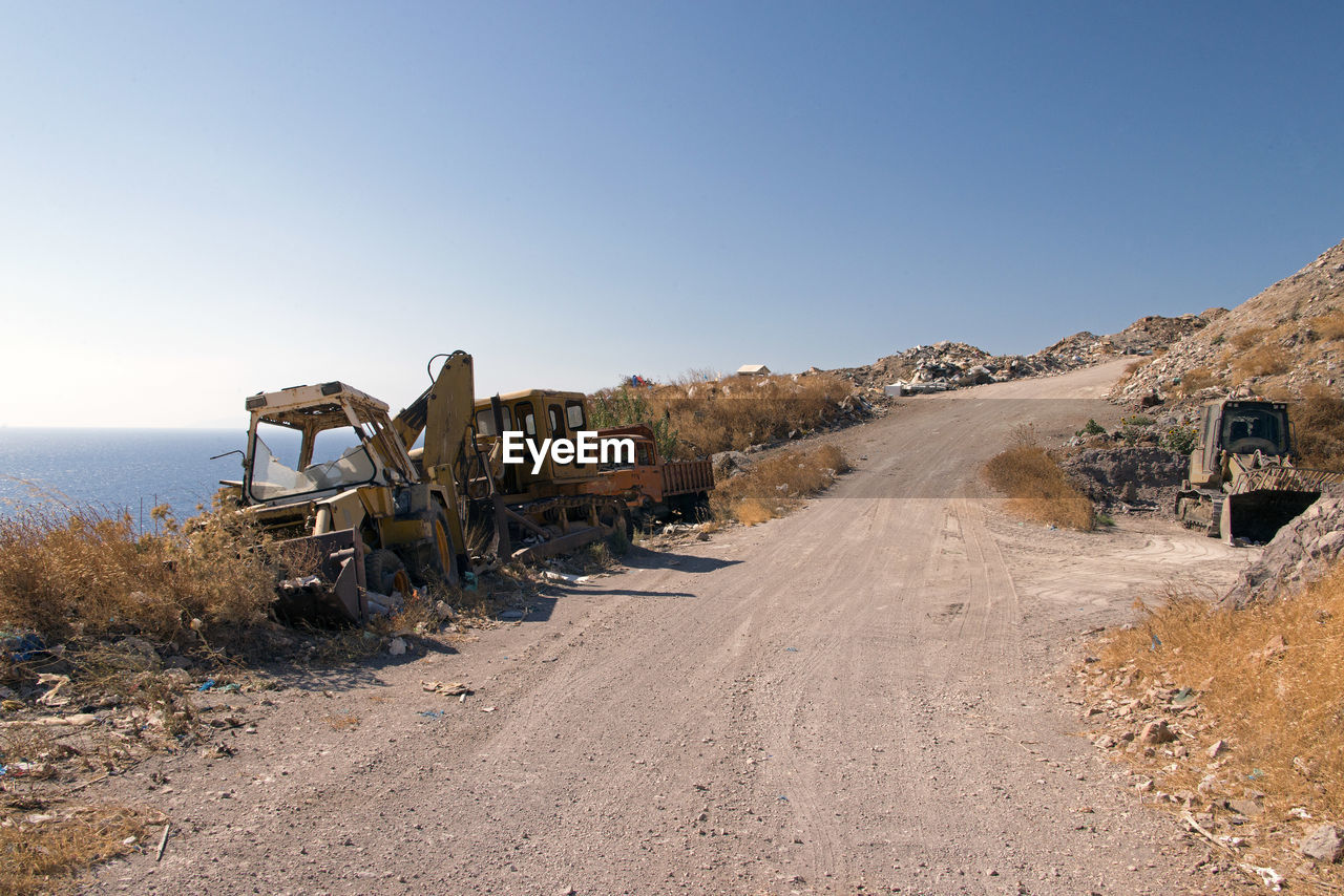 Wrecked and abandoned cars and ships in a remote location in the island